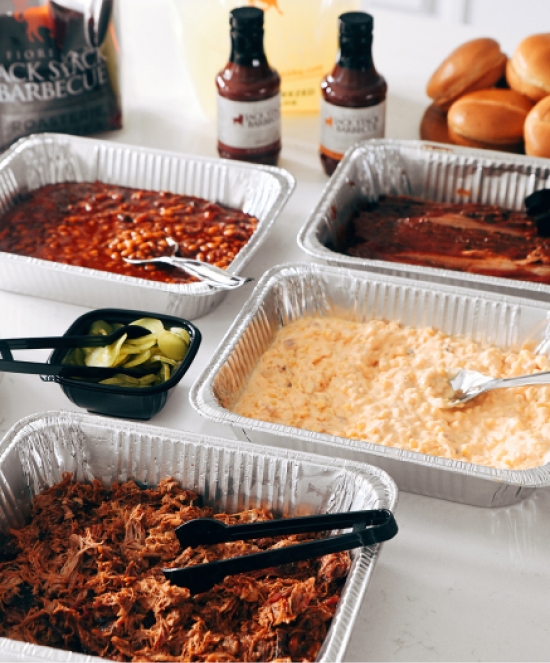Aluminum trays of pulled pork, baked beans, pickles, etc.